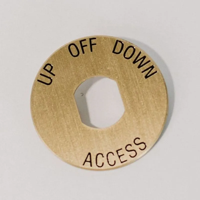 A round brass elevator dial plate reading Up, Off, Down, and Access