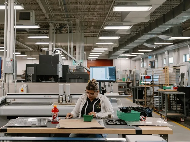 A wide view of the production floor with an operator working at a bench