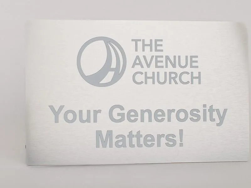 An engraved plaque reading The Avenue Church, Your Generosity Matters