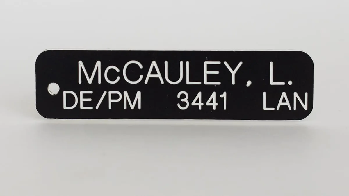 A black engraved phenolic name badge with white lettering